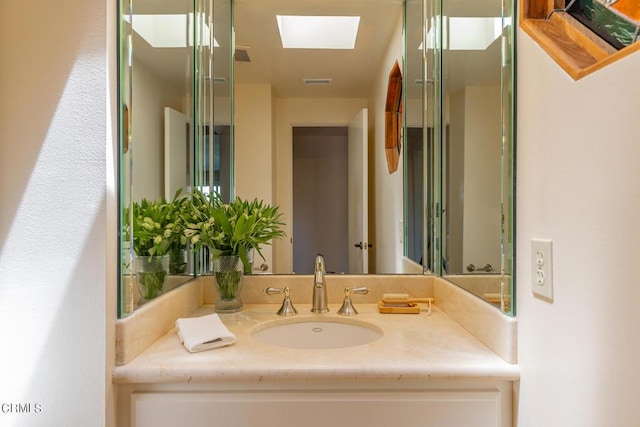 bathroom with visible vents, a skylight, and vanity