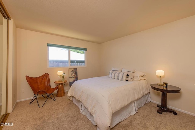 bedroom featuring light colored carpet and baseboards