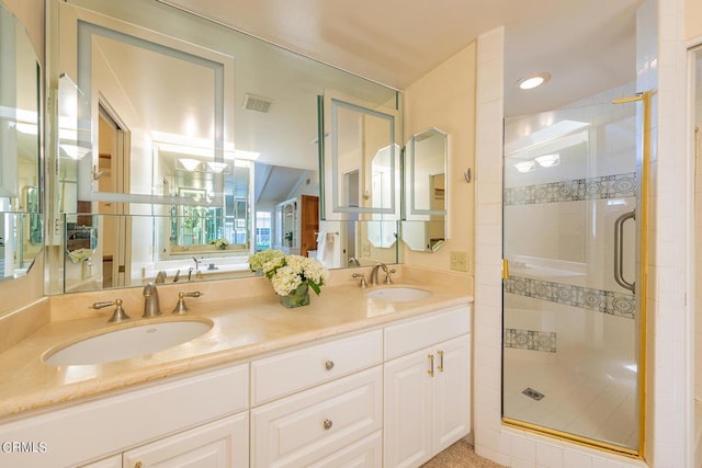 full bathroom featuring double vanity, visible vents, a shower stall, and a sink