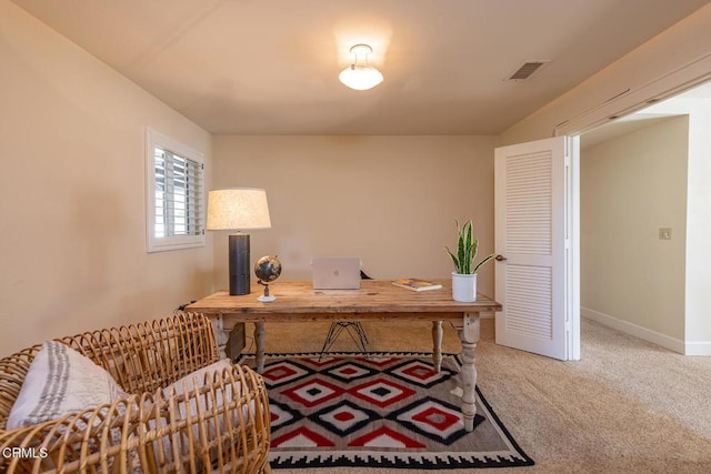 carpeted office space featuring visible vents and baseboards