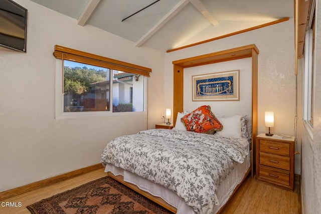 bedroom with wood finished floors, lofted ceiling with beams, and baseboards