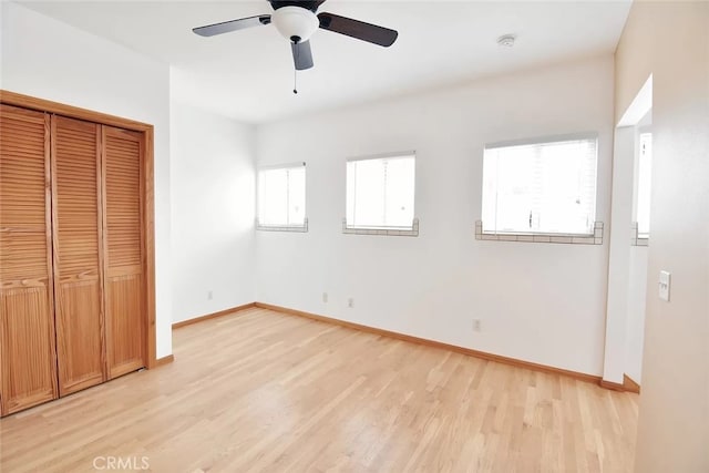 unfurnished bedroom with ceiling fan, a closet, and light wood-type flooring