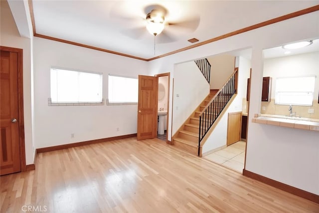 unfurnished living room featuring crown molding, plenty of natural light, and light hardwood / wood-style flooring