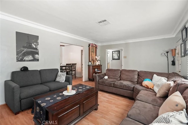 living room with light wood-type flooring and ornamental molding