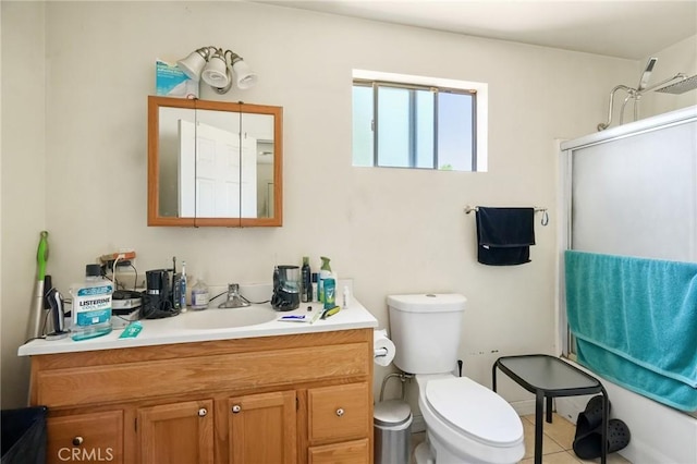 bathroom featuring tile patterned flooring, vanity, toilet, and an enclosed shower