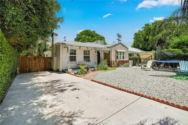 view of front of property featuring a trampoline and a patio