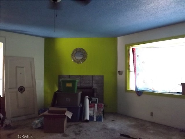 miscellaneous room with a textured ceiling, carpet, and ceiling fan