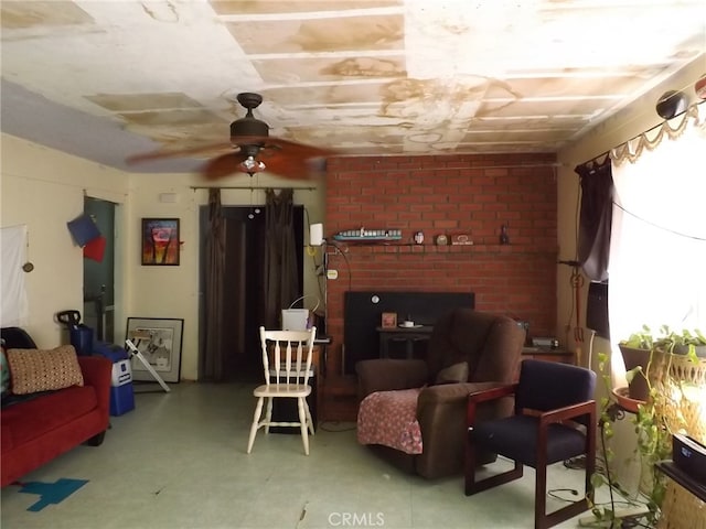 living room featuring a brick fireplace, concrete floors, and ceiling fan