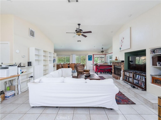 tiled living room featuring high vaulted ceiling and a stone fireplace