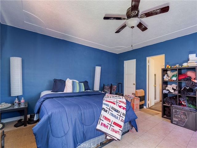 bedroom featuring tile patterned flooring, ceiling fan, and a textured ceiling