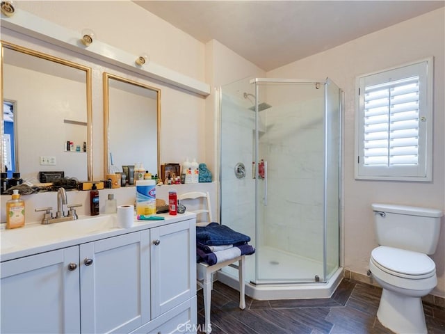 bathroom featuring toilet, vanity, and walk in shower