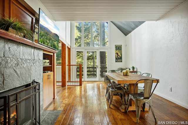 dining area featuring light hardwood / wood-style floors, lofted ceiling, and a fireplace