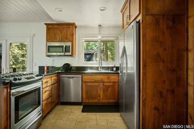 kitchen featuring stainless steel appliances, hanging light fixtures, and sink