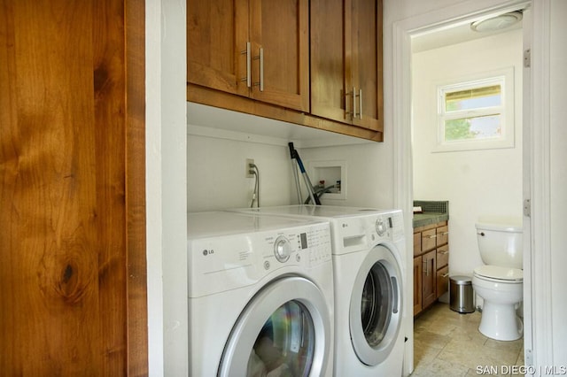 clothes washing area with cabinets and washing machine and clothes dryer