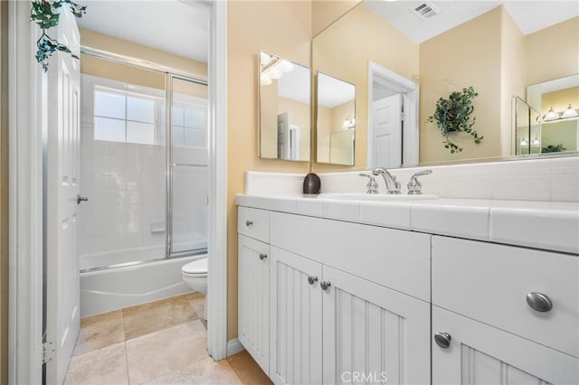 full bathroom with toilet, tile patterned flooring, vanity, and combined bath / shower with glass door