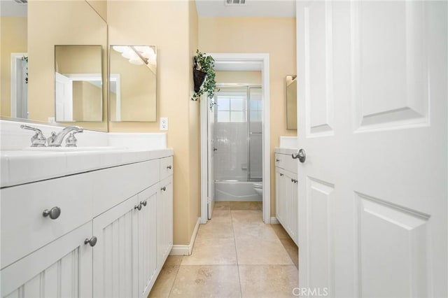 full bathroom with tile patterned floors, toilet, vanity, and combined bath / shower with glass door