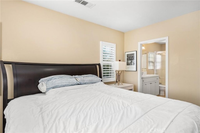 bedroom featuring multiple windows and ensuite bath