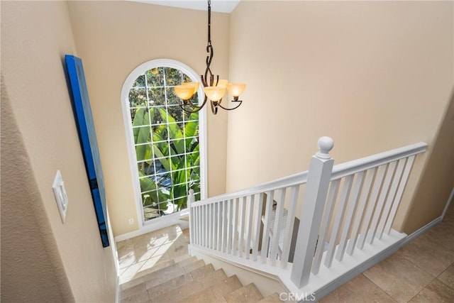 stairs with a chandelier