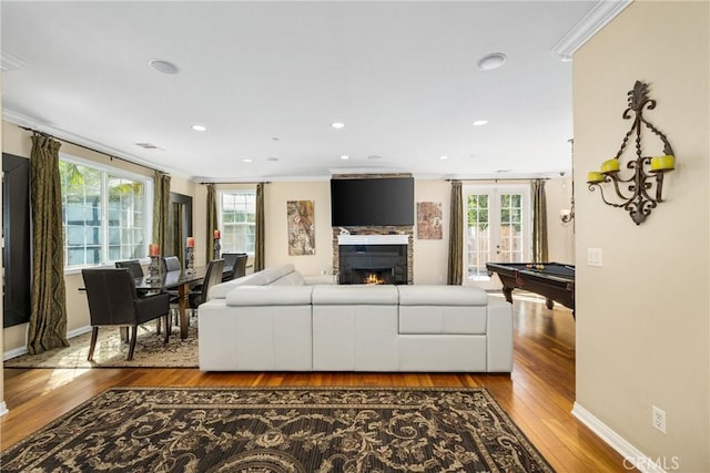 living room with a wealth of natural light, crown molding, french doors, and light wood-type flooring