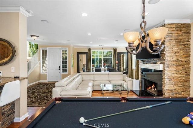 game room featuring a stone fireplace, ornamental molding, and billiards