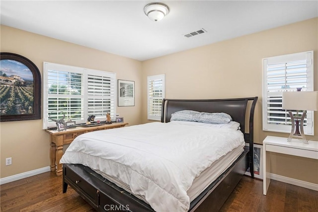 bedroom with dark hardwood / wood-style floors and multiple windows