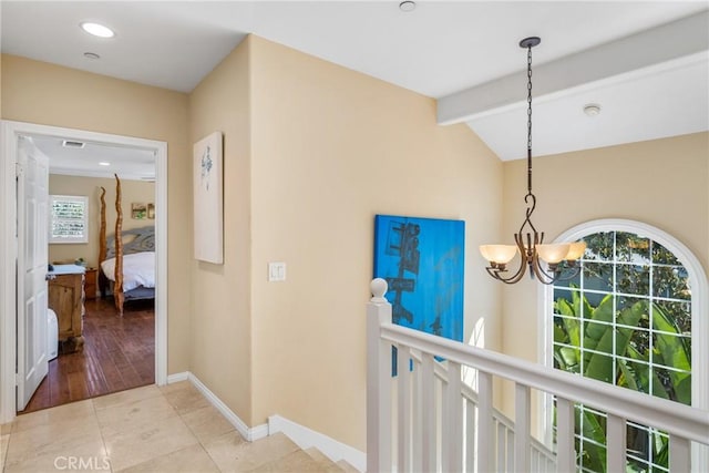 hallway with a chandelier, a wealth of natural light, light tile patterned floors, and lofted ceiling with beams