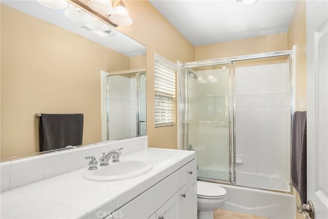 full bathroom featuring vanity, toilet, and bath / shower combo with glass door