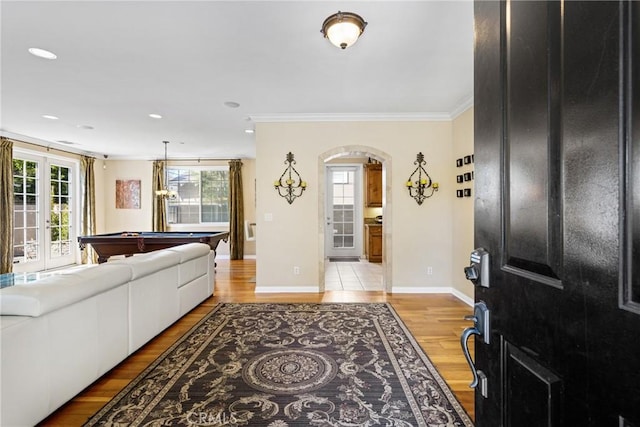 entryway with light hardwood / wood-style flooring, ornamental molding, french doors, and billiards