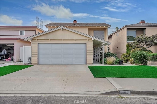 view of property featuring a garage and a front lawn