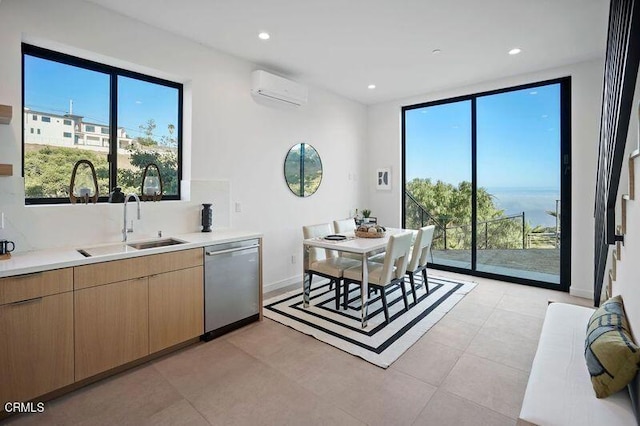 kitchen with sink, light tile patterned flooring, stainless steel dishwasher, and a wall mounted air conditioner