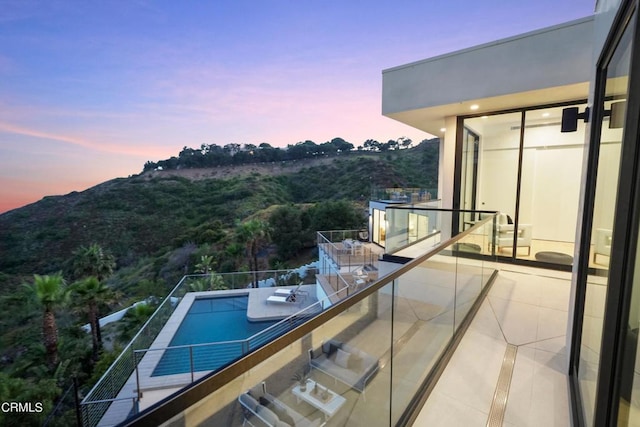 pool at dusk featuring a mountain view