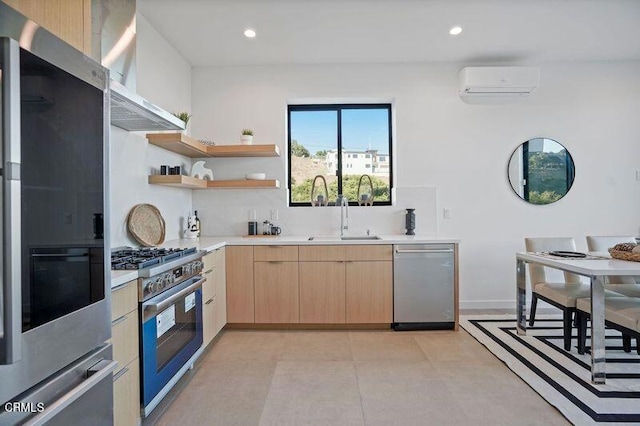 kitchen with sink, wall chimney exhaust hood, a wall mounted AC, light brown cabinetry, and appliances with stainless steel finishes