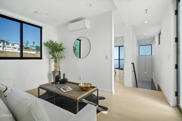 living room with light hardwood / wood-style floors and a wall mounted AC