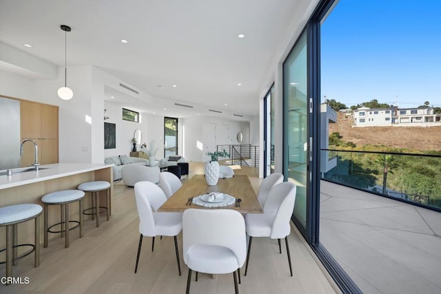 dining space with light hardwood / wood-style flooring and sink