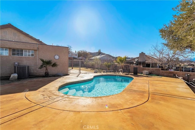 view of swimming pool with central air condition unit and a patio