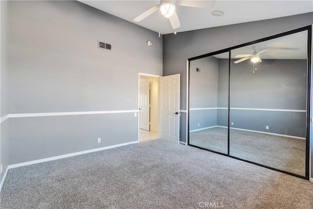 unfurnished bedroom with light carpet, high vaulted ceiling, a closet, and ceiling fan