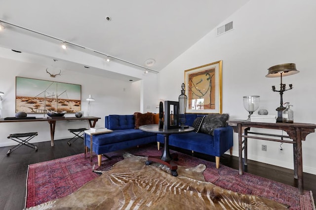 living room with dark hardwood / wood-style floors, lofted ceiling, and rail lighting