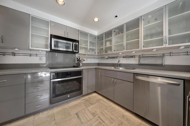 kitchen featuring backsplash, gray cabinets, sink, and appliances with stainless steel finishes