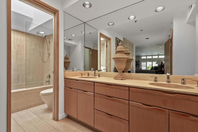 full bathroom with tile patterned flooring, vanity, tiled shower / bath combo, and toilet