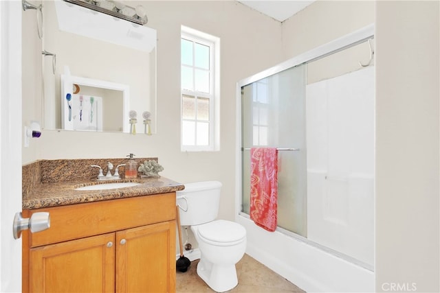 full bathroom with vanity, combined bath / shower with glass door, a healthy amount of sunlight, and toilet