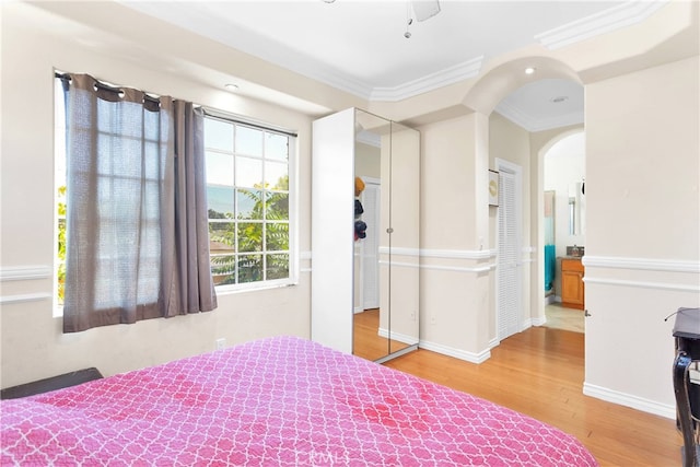 bedroom with ornamental molding, a closet, ceiling fan, and hardwood / wood-style floors