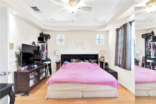 bedroom featuring a raised ceiling, hardwood / wood-style floors, and ceiling fan