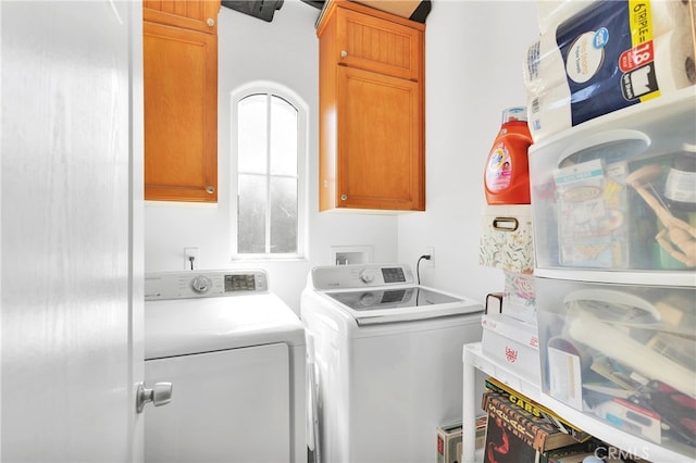 laundry area featuring washing machine and dryer and cabinets