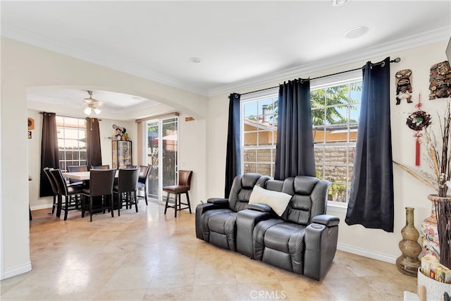 tiled living room with ornamental molding, ceiling fan, and a healthy amount of sunlight