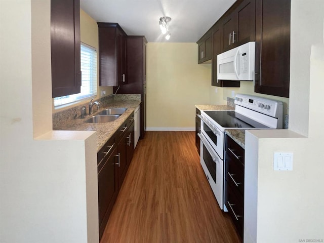 kitchen with dark hardwood / wood-style floors, dark brown cabinets, white appliances, and sink