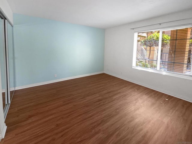 unfurnished bedroom featuring dark hardwood / wood-style floors and a closet