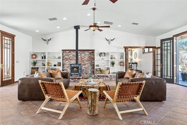 living room with lofted ceiling, french doors, a wood stove, and ceiling fan