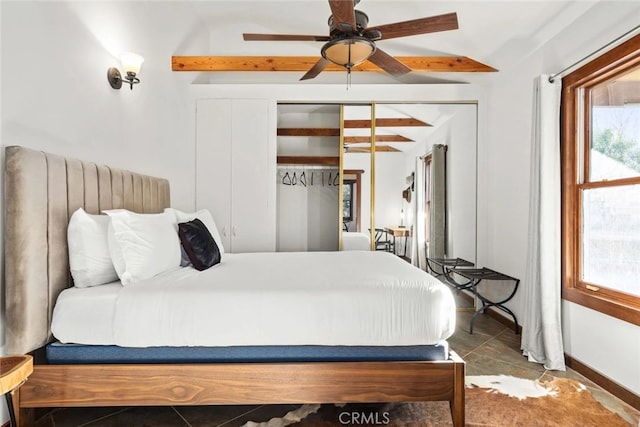 tiled bedroom with a closet, lofted ceiling with beams, and ceiling fan