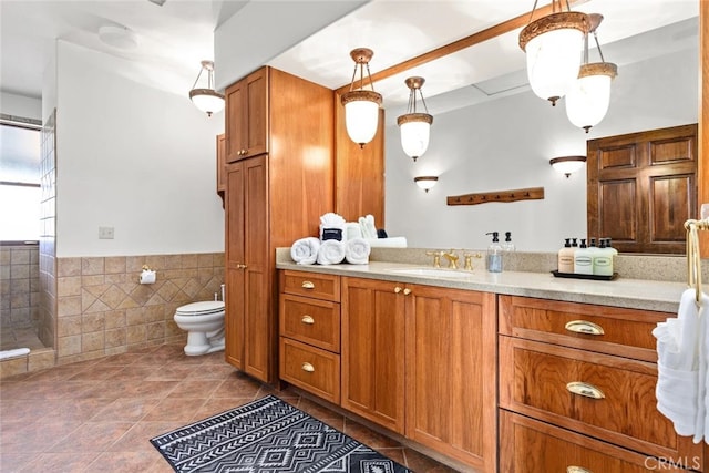 bathroom with vanity, toilet, tile patterned floors, and tile walls