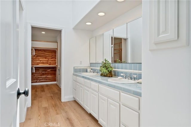 bathroom featuring hardwood / wood-style flooring, vanity, and backsplash